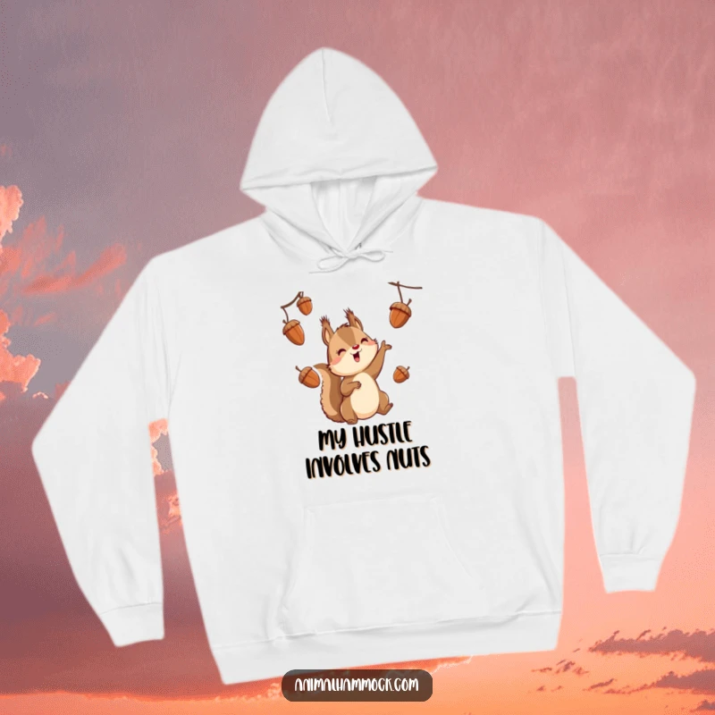 Funny squirrel character suspended, juggling acorns with a playful expression, printed on a cozy hoodie.