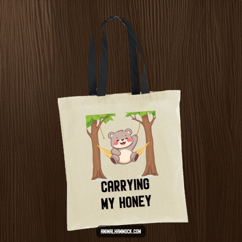 Funny chubby bear cub gleefully dangling from a hammock strung between two trees, perfect for this tote bag.