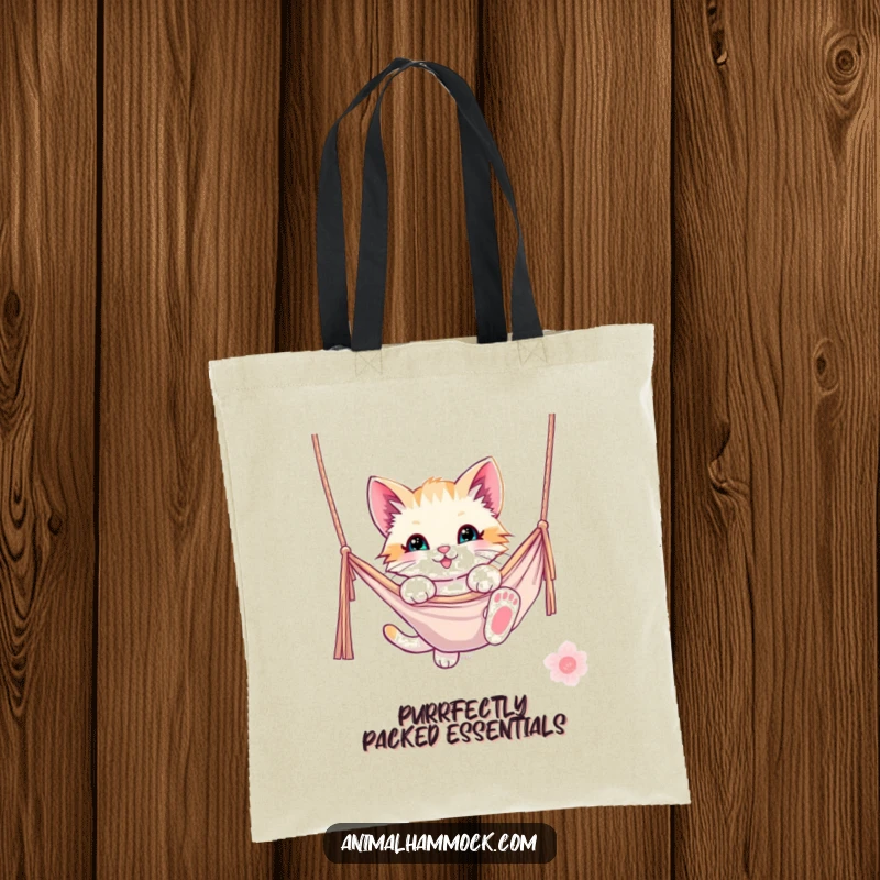 Funny kitten tote bag with a playful kitten dangling from a hammock, showcasing a delightful and humorous cat-themed design. A practical accessory.